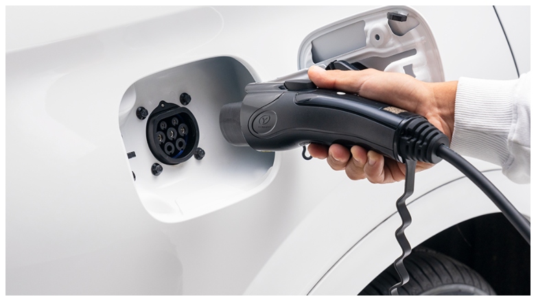 <p>Persona enchufando la SUV DFSK E5 hibrida para carga.</p>
