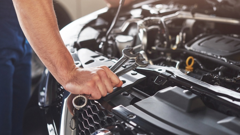 <p>Técnico vehícular revisando el estado de un motor de vehículo.</p>