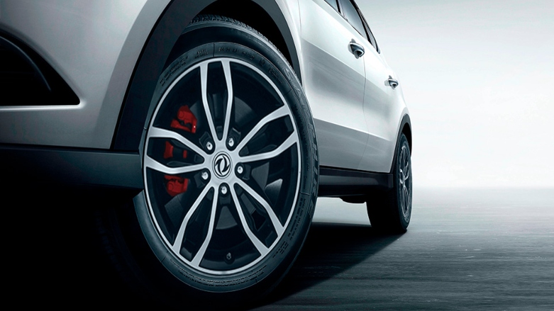 Vista cercana de rueda delantera de SUV DFSK Glory 580 con frenode disco rojo.